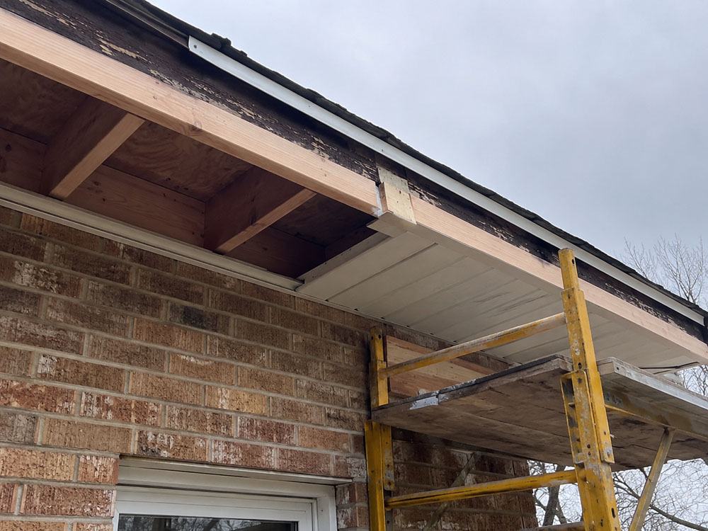 Soffit and fascia rebuild in progress with new framing and scaffolding
